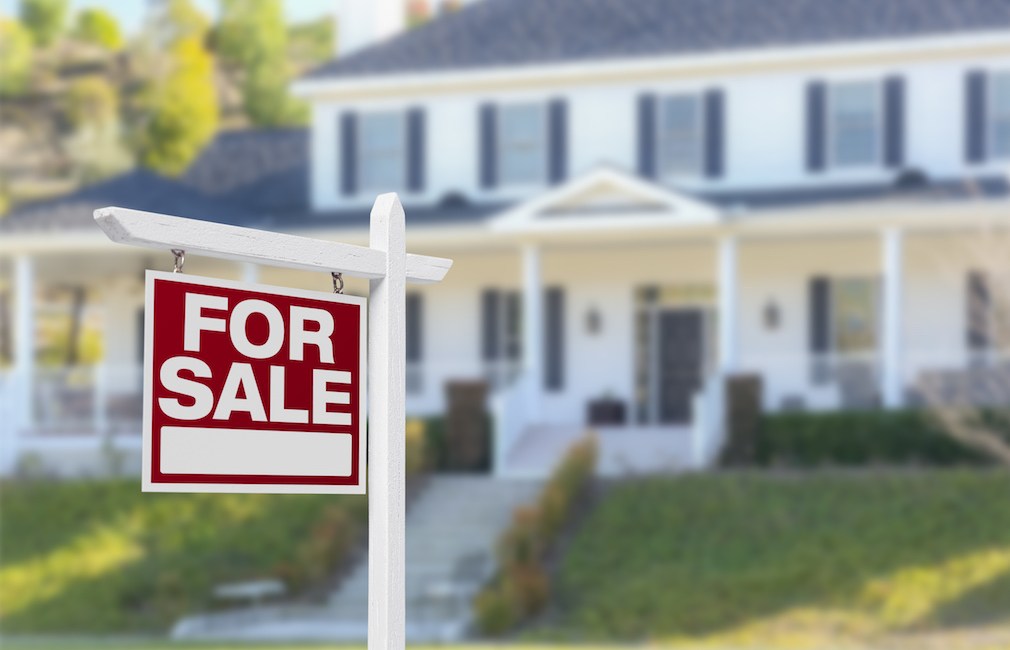 Home For Sale Real Estate Sign in Front of Beautiful New House.