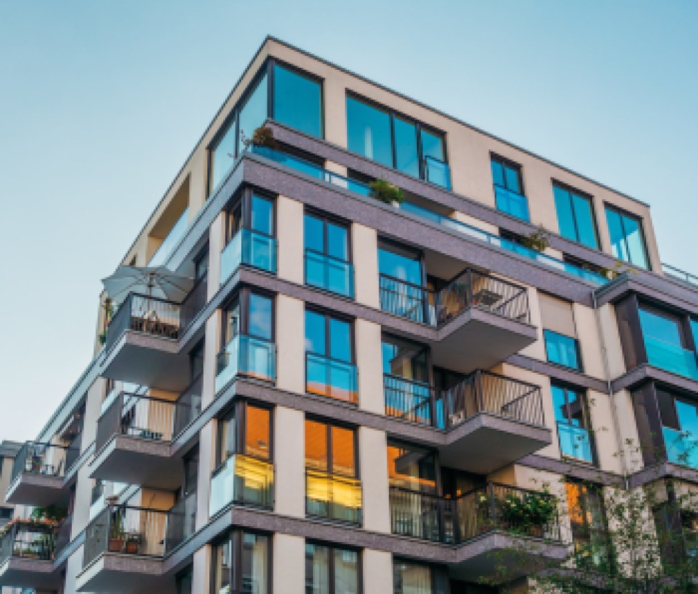 modern corner apartment complex with blue colored windows and light leaks