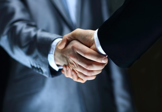 Handshake - Hand holding on black background