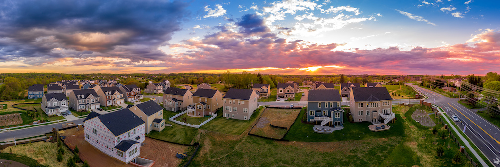 Aerial view of new construction street with luxury houses in a Maryland upper middle class neighborhood American real estate development in the USA with stunning sunset color sky