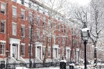 Snow covered winter street scene with old buildings along Washington Square Park in Manhattan New York City NYC