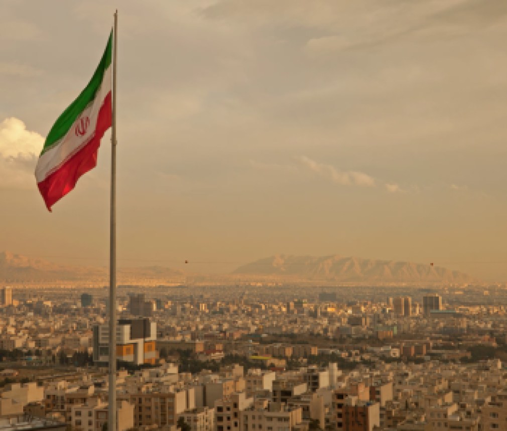 Iran Flag in the Wind Above Skyline of Tehran