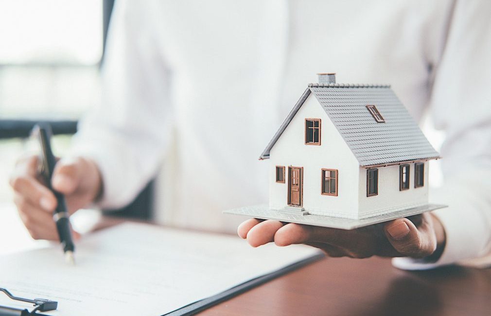 House model with real estate agent and customer discussing for contract to buy house, insurance or loan real estate background.