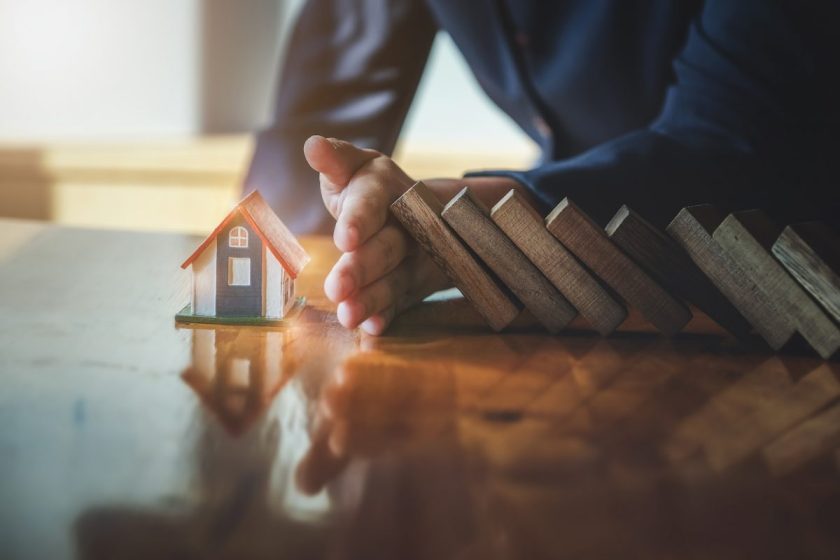 Business risk control Real estate concept, Businessman protect wooden block fall to planning and strategy in risk estate to business Alternative and prevent. Investment Insurance Business.