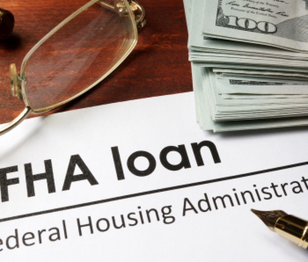 Paper with words fha loan on a wooden background.