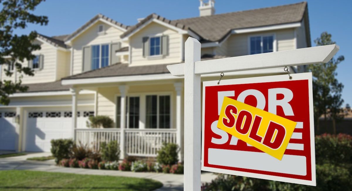 Sold Home For Sale Sign in Front of Beautiful New House.