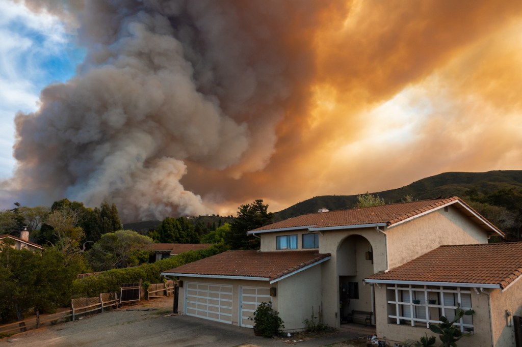 The California "River Fire" of Salinas,  in Monterey County, was ignited by dry lightning on August 16, 2020, fills the sky with dark smoke and flames as it burns close to a houses on its first day.