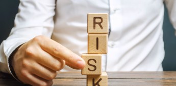 Man removes blocks with the word Risk. The concept of reducing possible risks. Insurance, stability support. Legal protection of business interests. Favorable investment climate. Financial pillow.