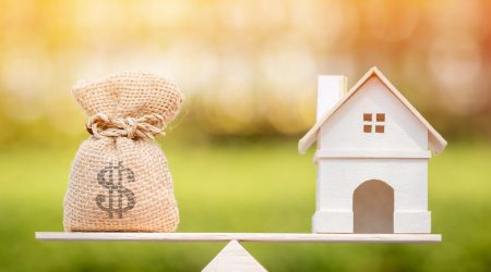 loan balancing on a scale with a home