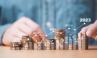 mortgage rates increase man stacking coins with graph showing increase every year