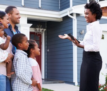 Real estate agent showing a family a house, closer in