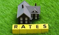 small model house with blocks that spell Rates mortgage rates concept