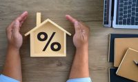 a model house with a percentage symbol sign inside of it mortgage rates