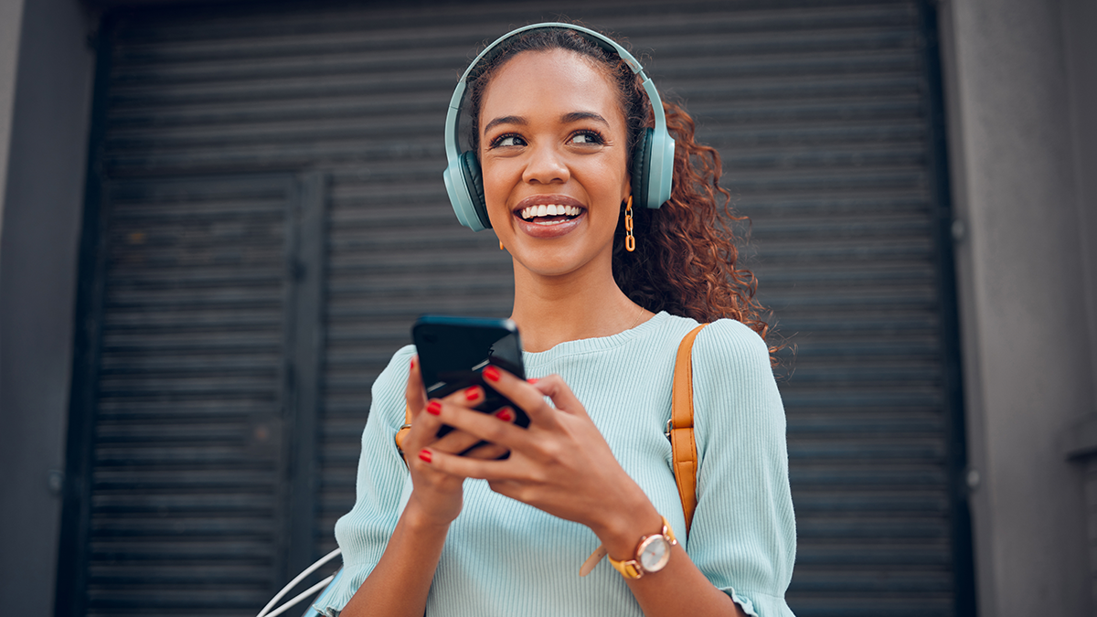 Woman with headphones listening to mobile phone