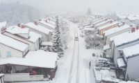 aerial view of middle income single-family home neighborhood covered in snow in winter