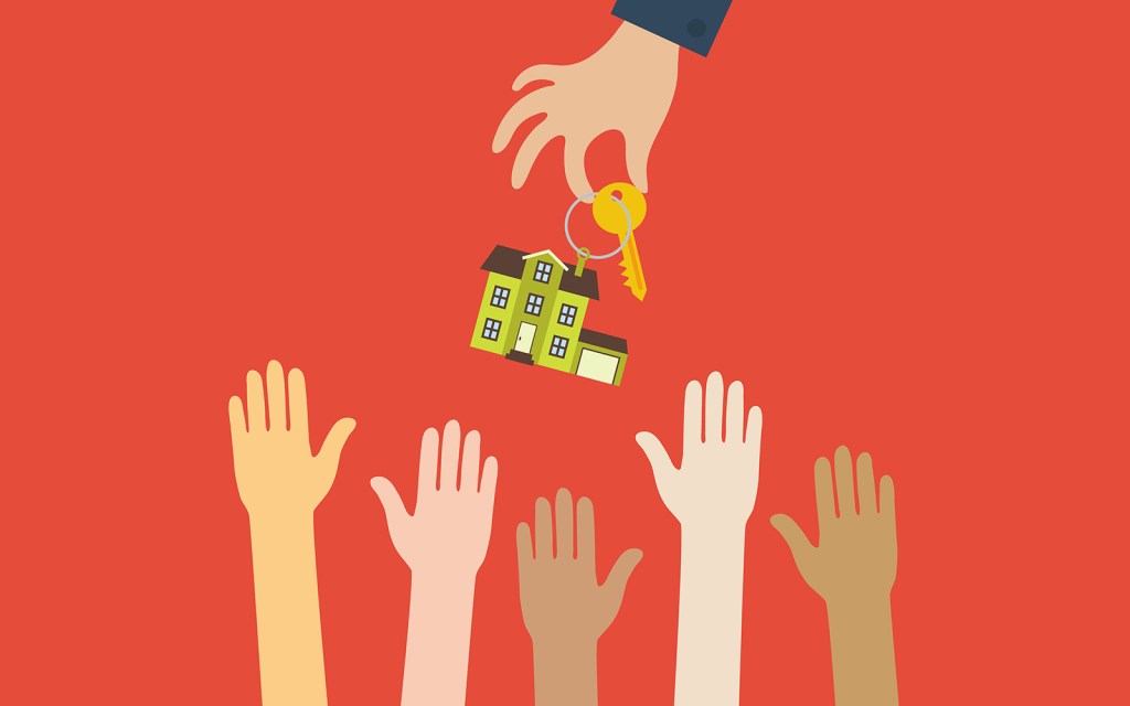 Hand real estate agent holding holds a key with a tag in the for