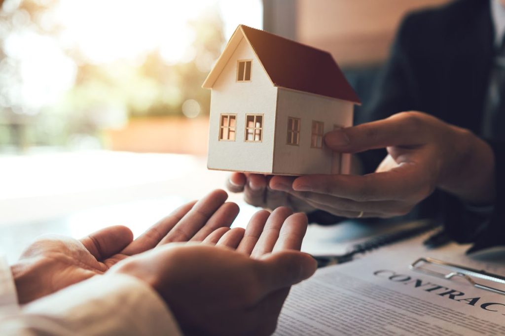 Real estate agent congratulations to new buyer by giving house m